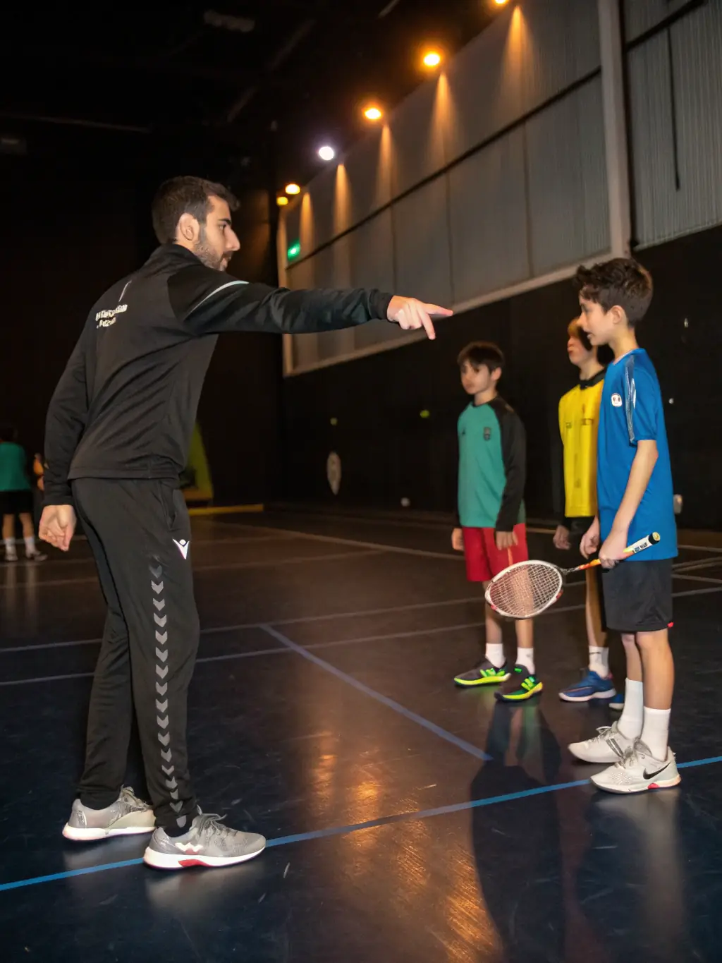 A focused image of a badminton coach providing personalized instruction to a player, emphasizing technique and skill development.